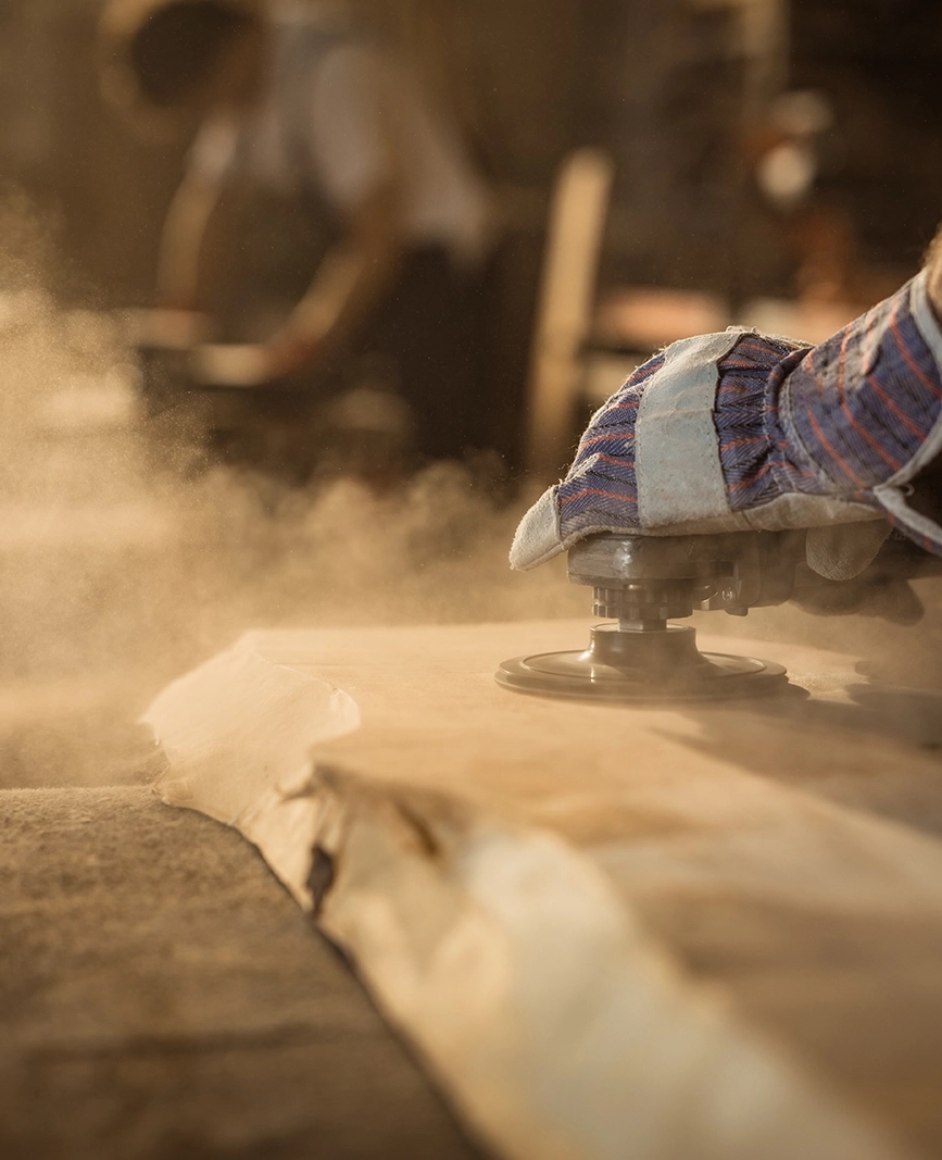 craftsmen sanding a live-edge wood table