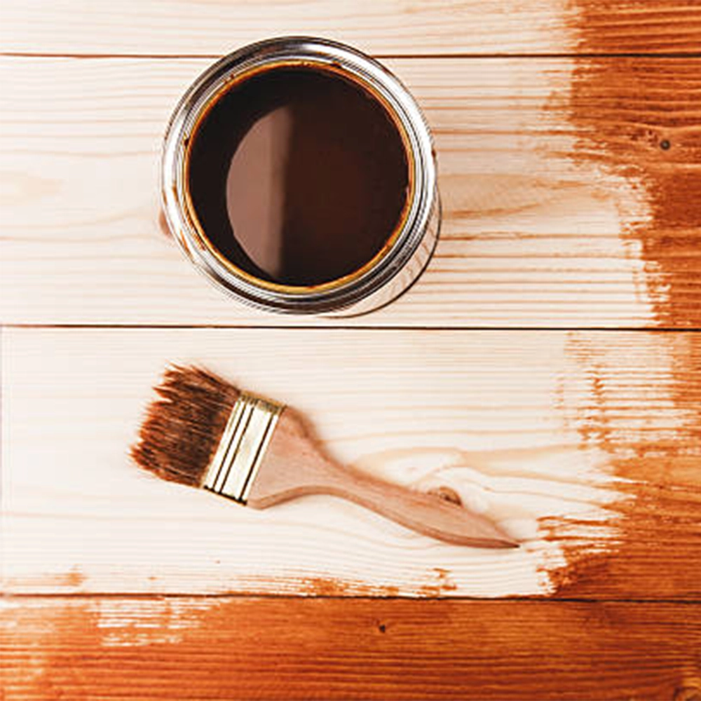 metal paint can of wood stain and a brush