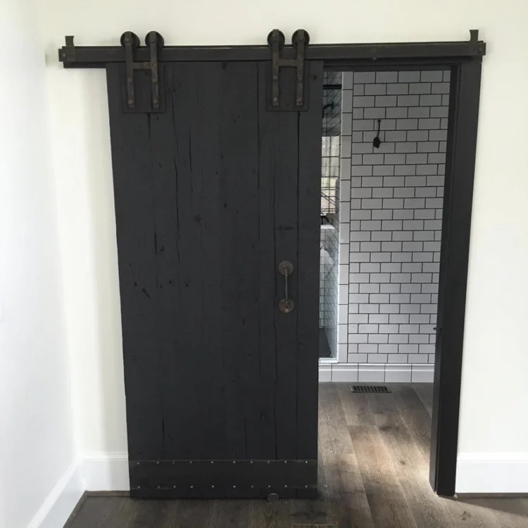 Painted black sliding barn door with black hardware