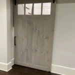 Gray interior sliding barn door with small glass windows