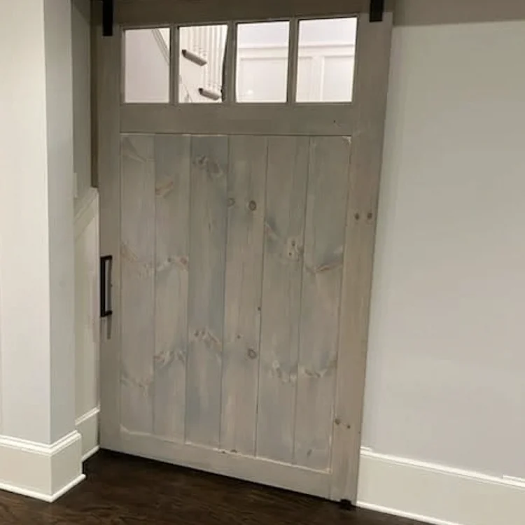 Gray interior sliding barn door with small glass windows