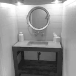 half bath with sink and vanity with shelving