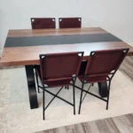 four metal dining chairs with leather seats at wooden table