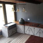 outdoor entertainment kitchen with white cabinets and Big Green Egg