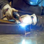Man welding a frame for outdoor seating